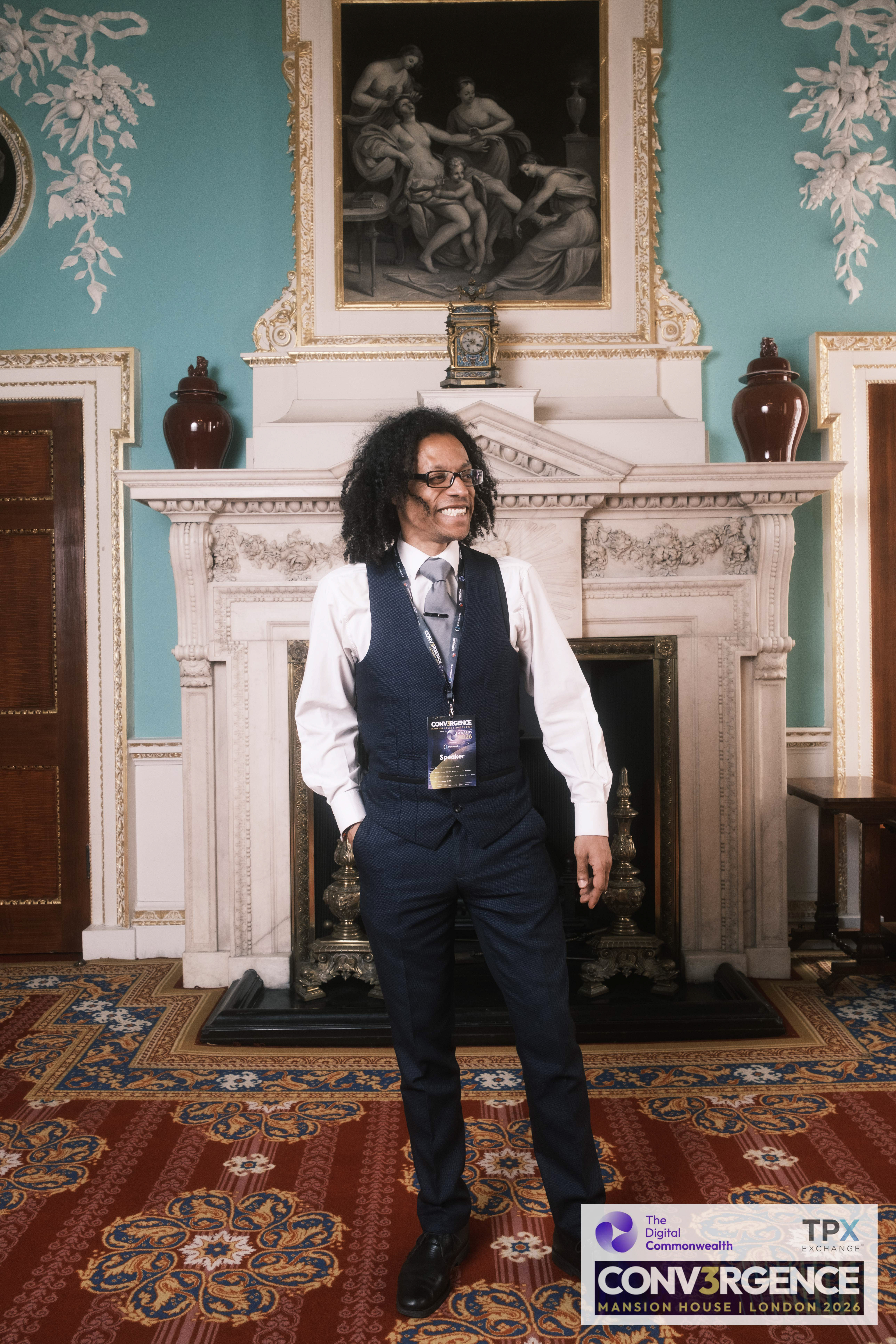 JB Webb-Benjamin smiling, standing by the fireplace in the Mansion House state rooms.